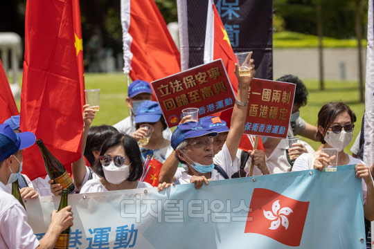 홍콩의 친(親)중국 지지자들이 30일 홍콩에서 집회를 열고 중국 오성기와 홍콩기(旗)를 흔들고 있다. 중국 전국인민대표대회(전인대) 상무위원회는 이날 '홍콩 국가보안법'(홍콩보안법)을 만장일치로 통과시켰다.        홍콩=EPA 연합뉴스